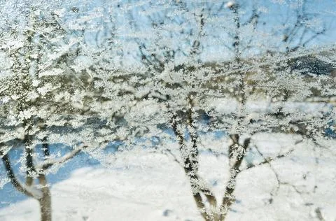 Snowflakes ice pattern with sunlight on winter window glass Stock Photos