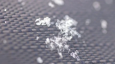 Snowflakes melting on a dark wicker surface Stock Footage 315067897