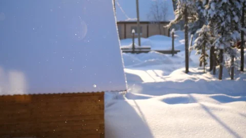 Snowflakes slowly fall to the ground, the bright sun illuminates the falling 库存影片 99589336