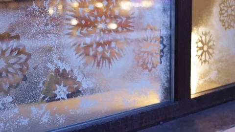 Snowflakes on the window glass in the evening. Camera movement from left to righ Stock Footage 83249110