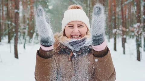 Snowing in the forest: woman in winter clothes making fun with snow. Stock Footage 157590853