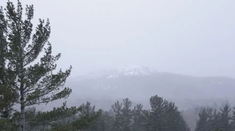 Snowing with mountain peak in the background Stock-Footage 37216906