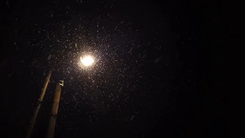 Snowing at night under a street pole Stock Footage