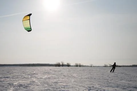 Snowkiting on the field on a background of trees and sun Stock Photos