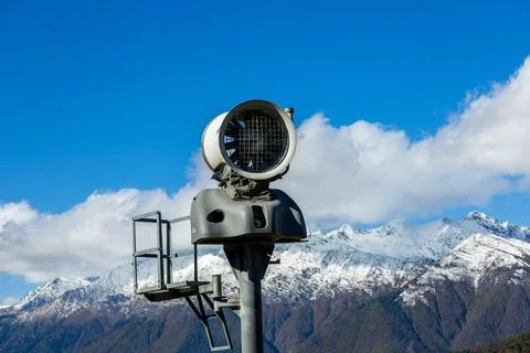 Snowmaking machine at mountain ski resort on sunny day Stock Photos