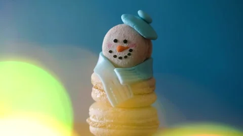 Snowman dessert macaron decorated with hat and scarf against colorful background Stock-Footage 255922428