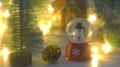 Snowman in globe with pine tree and shiny christmas lights with mist Stock Footage 166966780