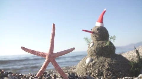Snowman on holidays made of sand instead of snow. Concept tropical resort Stock Footage 121739866