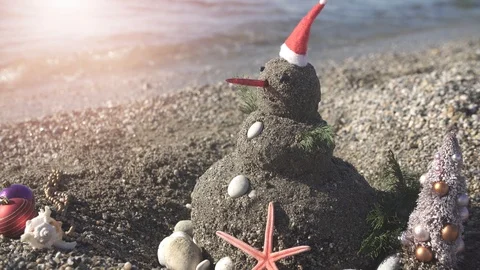 Snowman on holidays made of sand instead of snow. Concept tropical resort Stock Footage 121741470