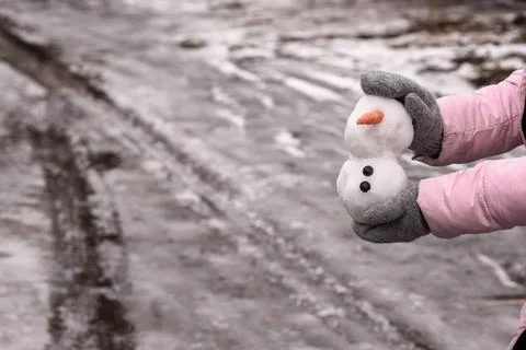 A snowman in mittened hands. arrival of spring Stock Photos