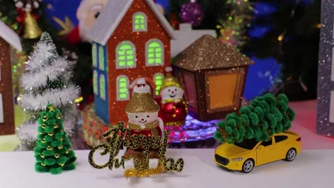 A snowman on a sled, featuring letters, set against of rotating little houses Stock Footage 348598289