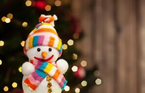 Snowman smiling in multi-colored hat and scarf Christmas toy on the backgroun Stock Photos