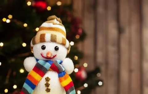 Snowman smiling in multi-colored hat and scarf Christmas toy on the backgroun Stock Photos