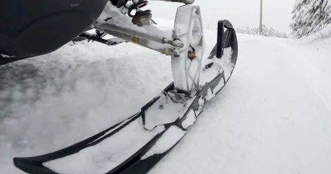 Snowmobile drive skiing fast through snowy mountain terrain on winter trail Stock Footage 323389773