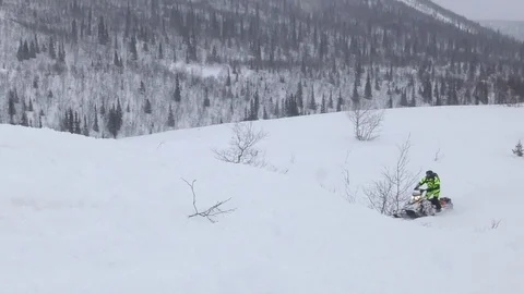 Snowmobile driver moves fast along boundless valley Stock Footage 112533972