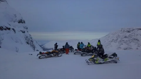 Snowmobile driver in protective helmet moves past friends Video stock 112532815