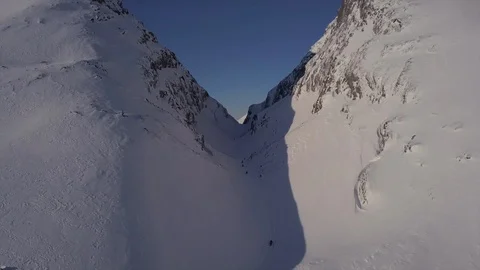 Snowmobile drivers move fast in line between high mountains Stock-Footage 112530711
