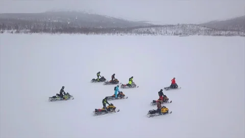 Snowmobile drivers move on valley under falling snow Video stock 112533084