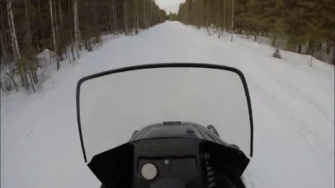 Snowmobile driving along the forest ski run. Stock Footage 69082276