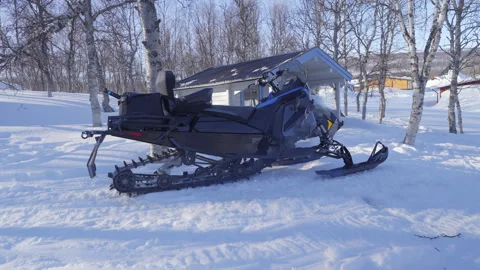 Snowmobile parked and warming up on a snow-covered ground with a winter cab.. Stock Footage 287073302