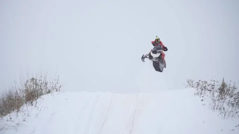 Snowmobile racing through the forest 動画素材 168842816