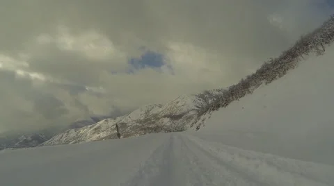 Snowmobile ride down mountain road winter POV HD Stock Footage 59781185