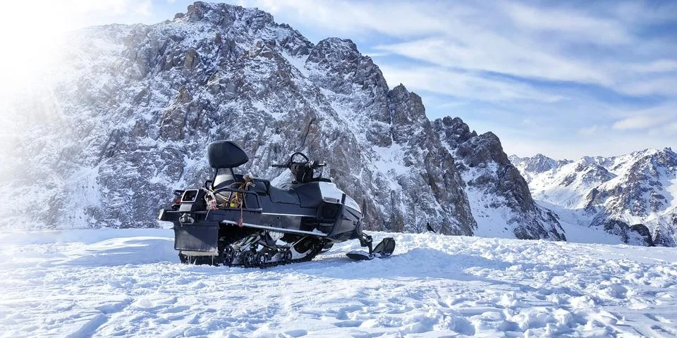 Snowmobile on the rocks background Stock Photos
