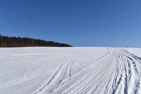 A snowmobile trail in a field Stock Photos