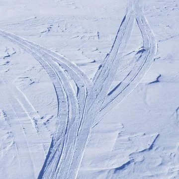 Snowmobile trail on a snow surface Stock Photos