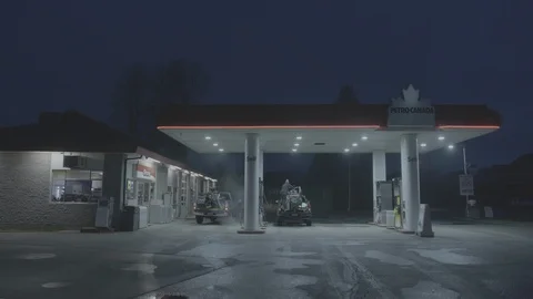 Snowmobiler fueling gas in morning at Petro Canada. Stock Footage