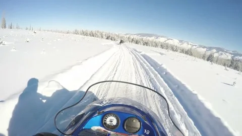 Snowmobiler rides through open field remote Colorado Stock Footage 75193882
