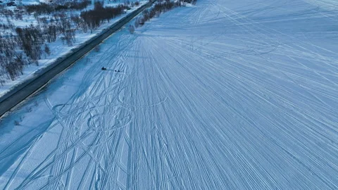 Snowmobiles pull unrecognizable children on small snow sledges Stock Footage 195557311