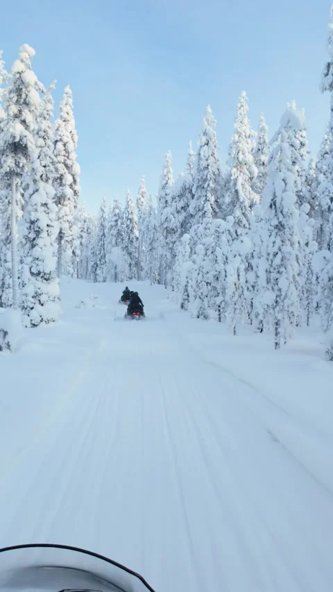 Snowmobiling adventure through the enchanting winter landscape of Akaslompolo Stock Footage 334096418