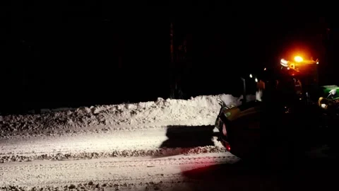 Snowplow machine clearing a snowy road at night Video stock 344104330