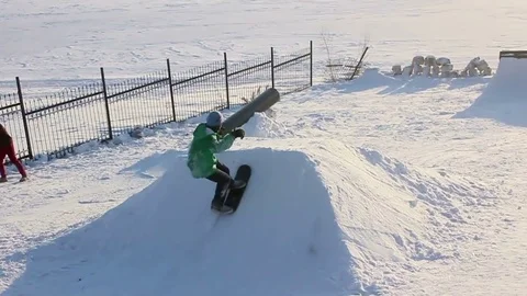 Snowskater jumping from springboard and doing tricks Stock Footage 69788726