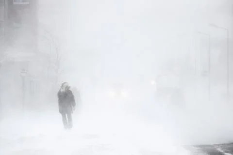 Snowstorm in the city. A man during a blizzard is walking along the street. Stock Photos