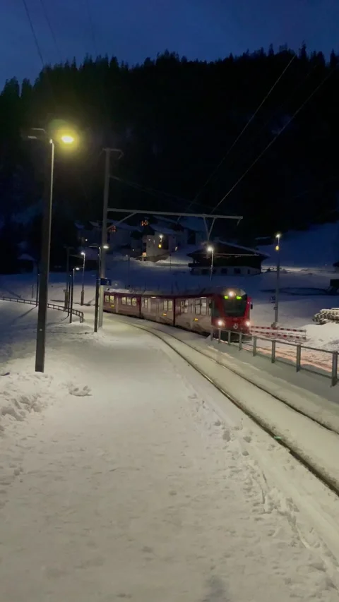 Snowy alpine peaks with pine trees and Swiss train in Switzerland Video stock 330585392