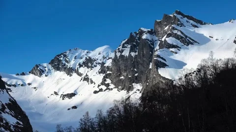 Snowy alpine peaks under bright cloudless blue sky Stock Footage 340962995