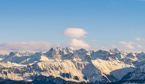 Snowy Alps mountain range viewed during a winter afternoon Stock Photos