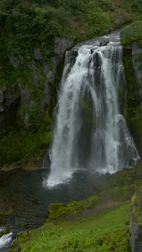 Snowy bar waterfall dropping into rocky basalt gorge in remote Kamchatka Russia Stock Footage 346558150