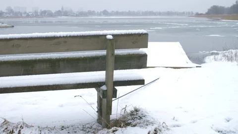 Snowy bench in front of a lake Stock-Footage 86859406