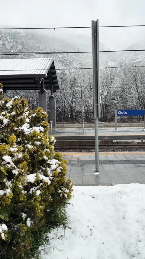 Snowy Bushes and Train Platform at Oulx Station with Alpine Mountains in Italy Stock Footage 342051551