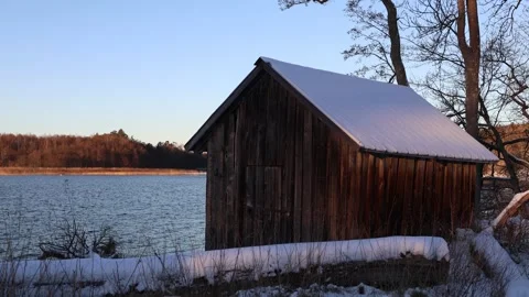 Snowy cabin at lake. Video stock 304630832