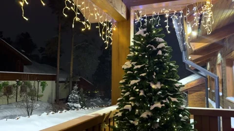 Snowy Christmas tree with glowing string lights at night. Stock Footage 327852294