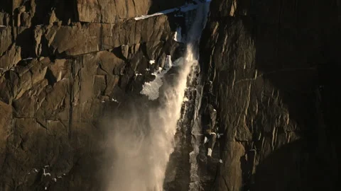 Snowy cliffs under sunlit spray. Misty rocks with shining water and rugged 動画素材 342946379