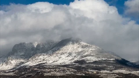 Snowy clouds and sun over the mountains, time lapse Stock Footage 70263686