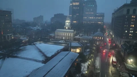 Snowy dusk view of Independence Hall in Philadelphia with glowing windows, car Vídeos de archivo 328354730