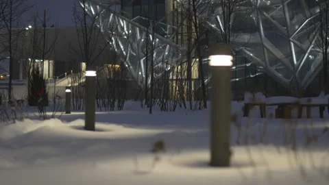 Snowy evening surrounds theater with sharp angular facade Video stock 326464425