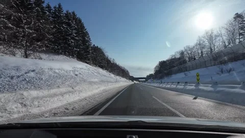 Snowy expressway drive passing under bridge with SOS phone and rest area sign Video stock 333229858