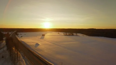 Snowy fields by a small highway during sunset Stock Footage 88205792